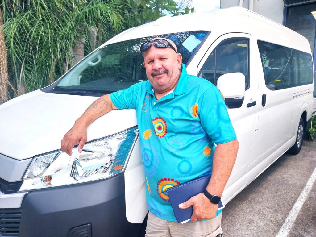 One of Katungul's transport drivers standing in front of a van.